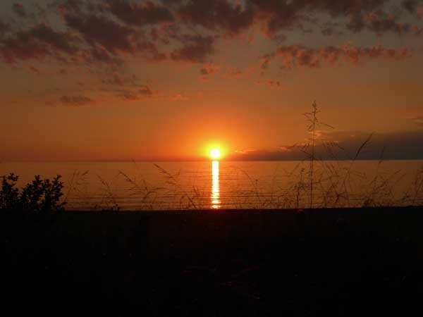 A deep orange sunset over Lake Huron